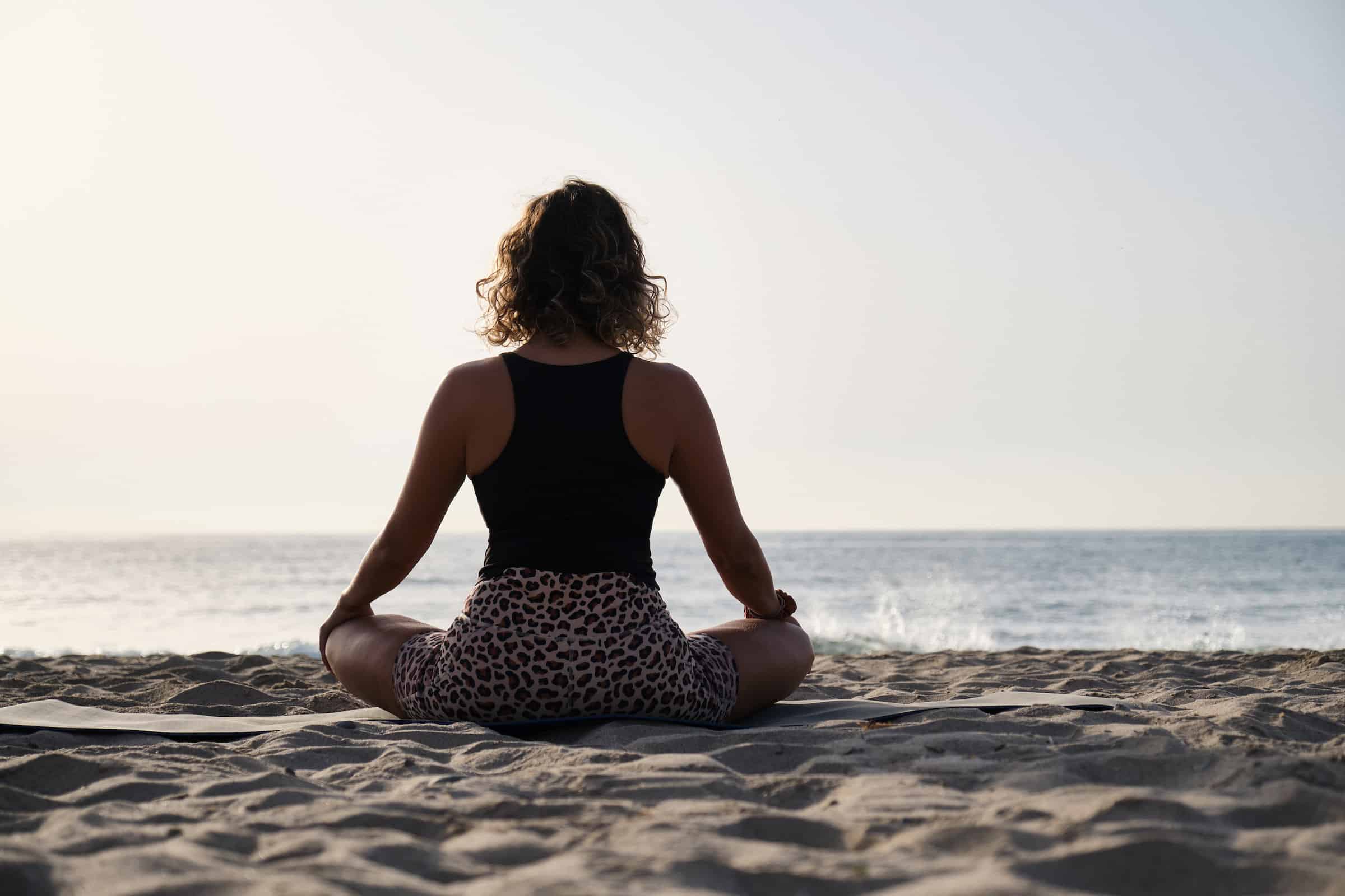Yoga on the beach A woman practicing yoga at the sunrise on the beach