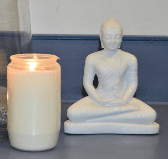 Buddha with candle Kleine weiße Buddhafigur neben einer Kerze